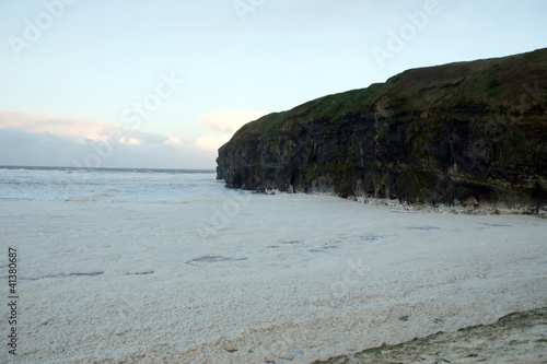 sweeping waves of foam beside cliffs