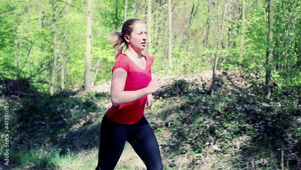 Young woman jogging in the forest, slow motion Young woman jogging in the forest, slow motion