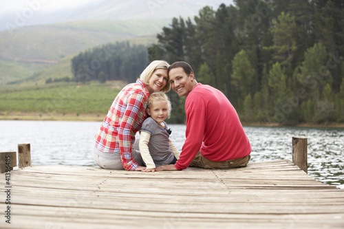 Young family sitting on a jetty
