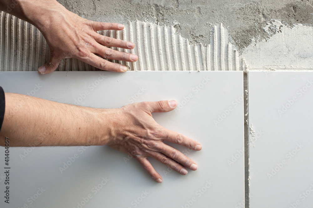 Foto construction mason man hands on tiles work