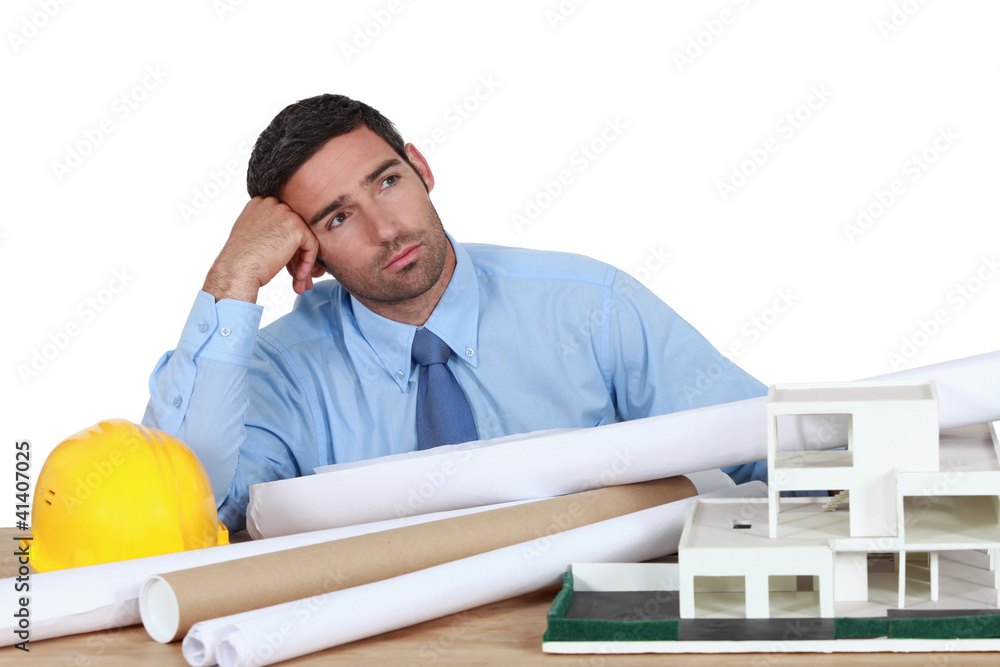 Obraz premium Bored architect sat at desk