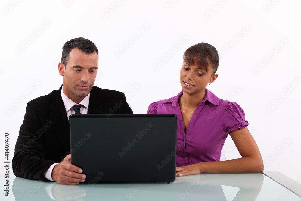 Businesspeople looking at a laptop Businesspeople looking at a laptop