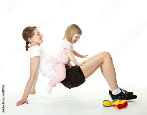 Young mother doing sport exercises with her little daughter