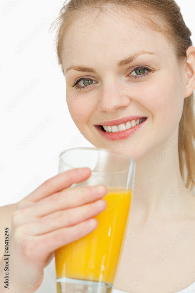 Cheerful woman holding a glass of orange juice Cheerful woman holding a glass of orange juice