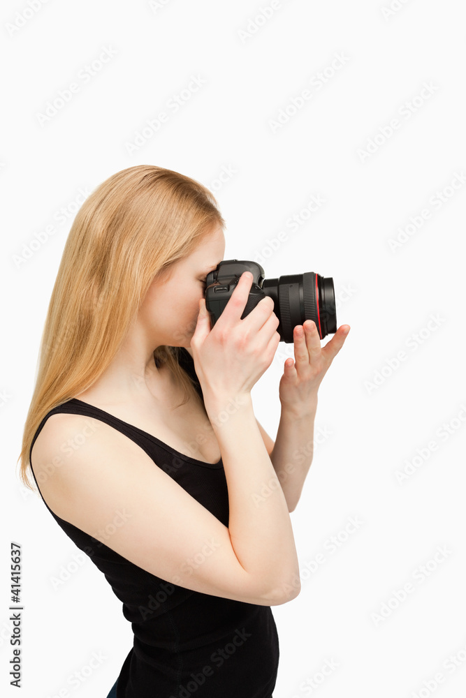 Blonde-haired woman aiming with a camera Blonde-haired woman aiming with a camera