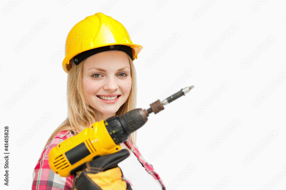 Woman holding an electric screwdriver while smiling Woman holding an electric screwdriver while smiling