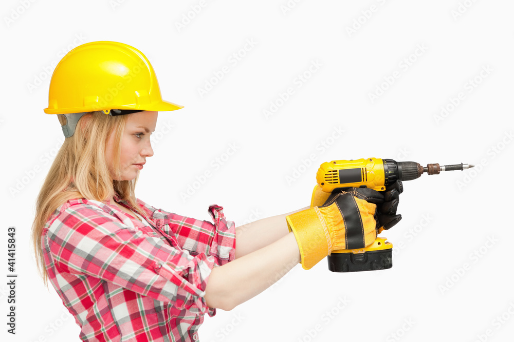 Serious woman using an electric screwdriver Serious woman using an electric screwdriver