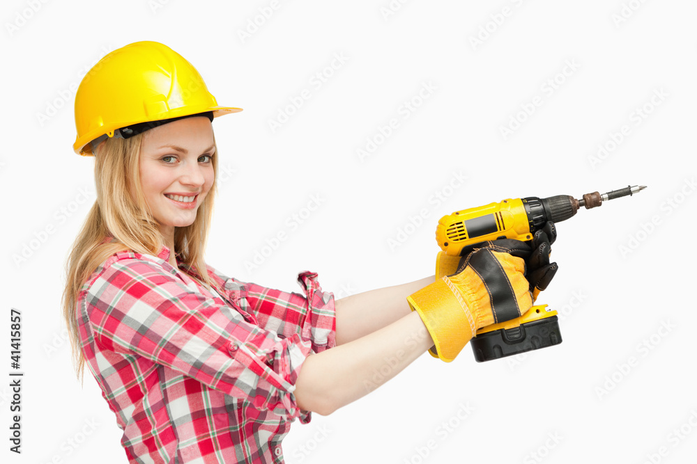 Smiling woman using an electric screwdriver Smiling woman using an electric screwdriver
