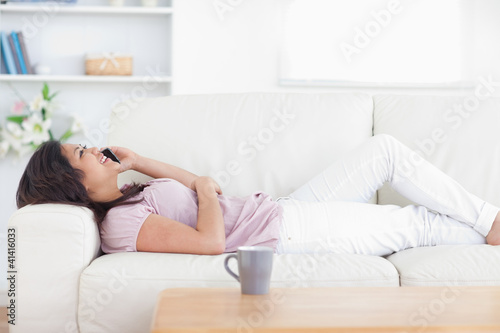 Woman relaxing as she holds a phone
