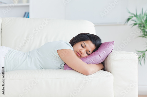 Woman holding a pillow while sleeping on a couch