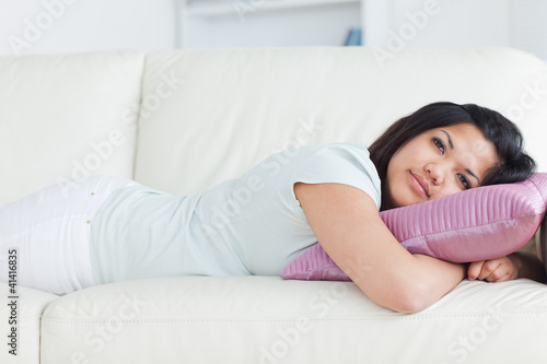 Woman on a sofa with her head resting on a pillow