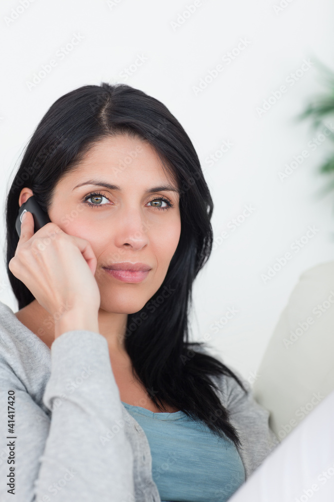 Woman phoning while resting on a couch Woman phoning while resting on a couch