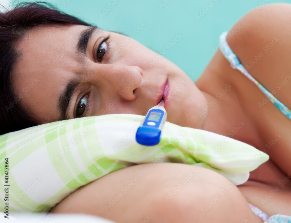 Naklejka premium Hispanic woman in her thirties sick in bed