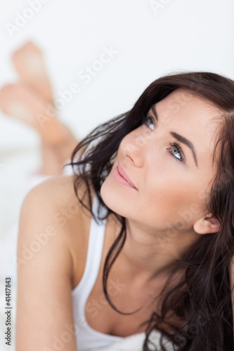 Thoughtful woman lying on her bed