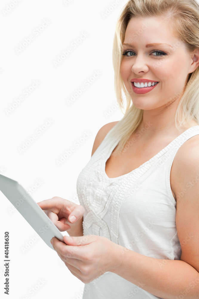Cheerful blonde woman touching her tablet computer Cheerful blonde woman touching her tablet computer