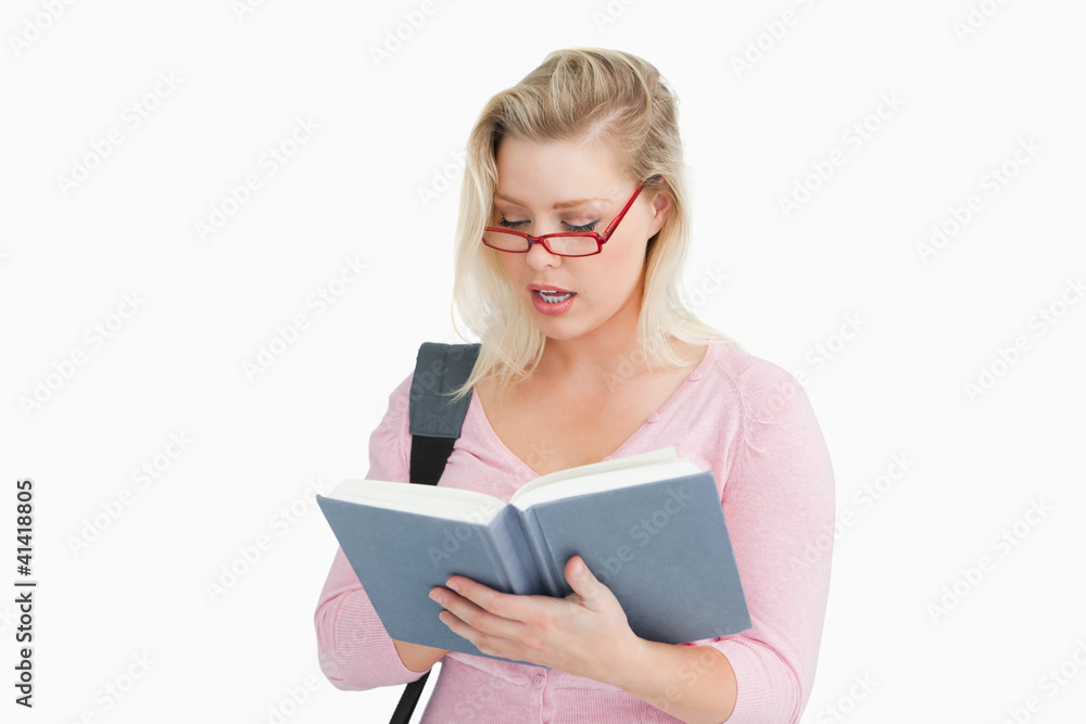 Serious woman reading a book while wearing glasses