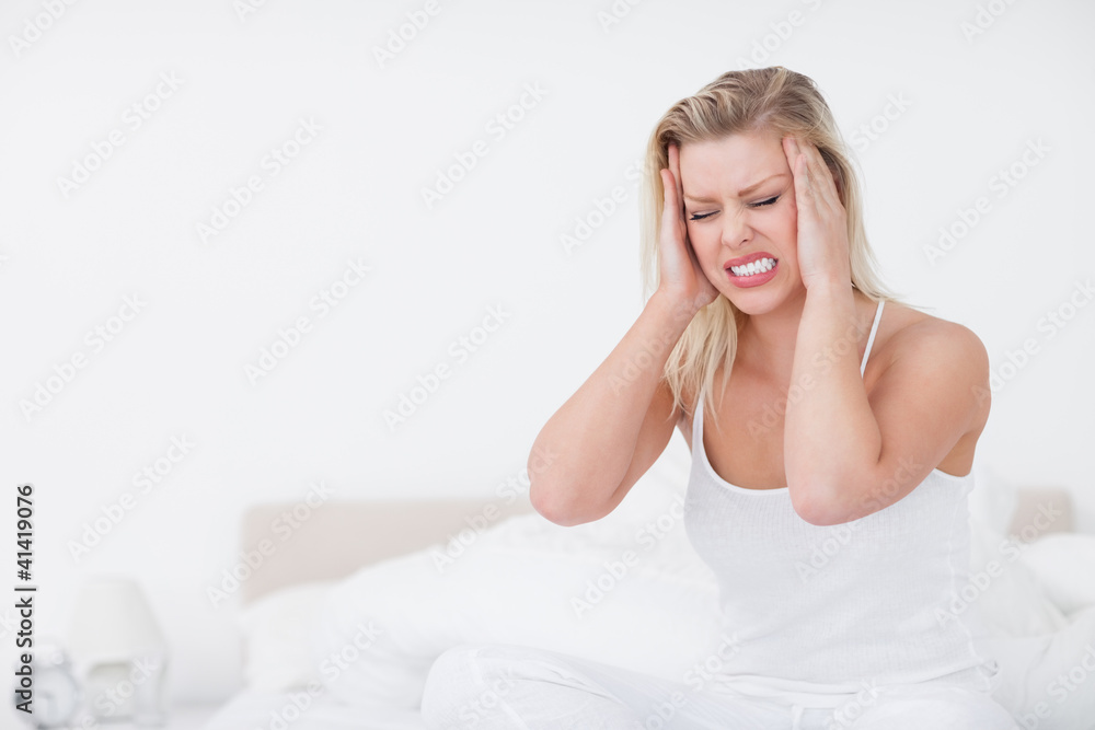 Blonde grimacing while having a headache Blonde grimacing while having a headache