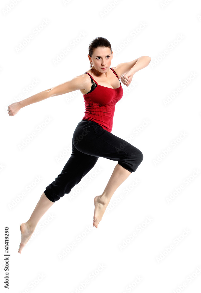 Girl in sportswear jumping jumping over white