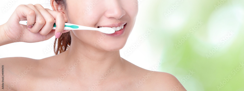 Naklejka premium woman brushing teeth with green background