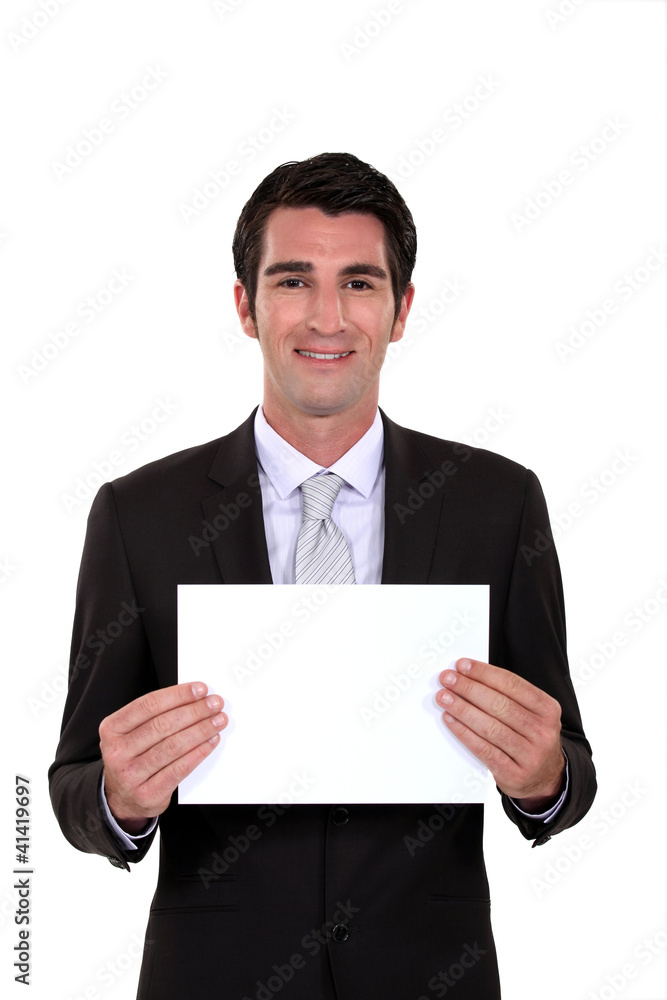 A businessman holding a blank poster. A businessman holding a blank poster.