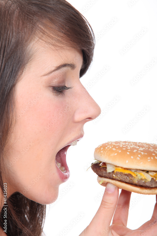 teenage girl eating an hamburger