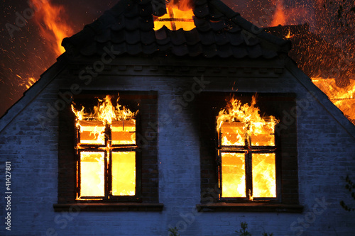 Burning in wild flames. House on fire. Dangerous blaze