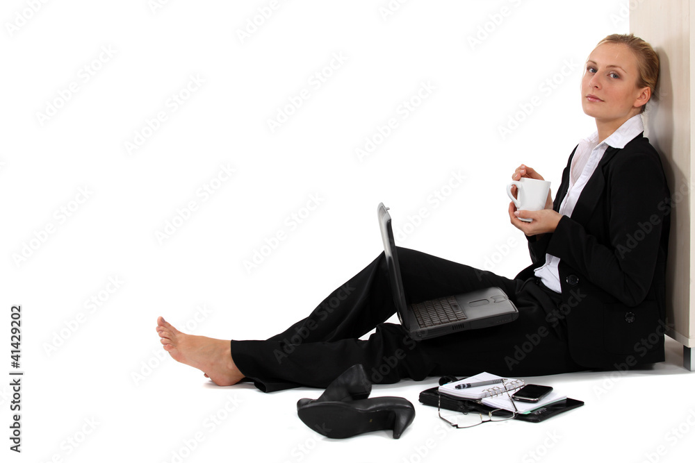 Barefoot businesswoman sat with coffee and laptop Barefoot businesswoman sat with coffee and laptop