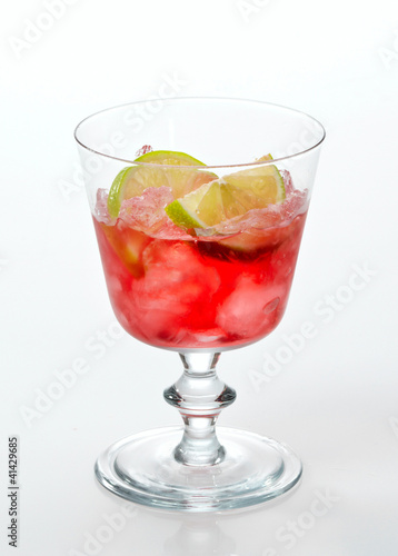 red cold drink with ice and lime