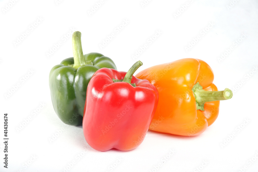 Three color red yellow green peppers in white background