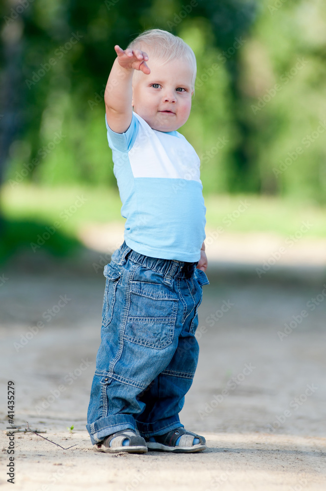 Fototapeta premium Happy little boy in the green park