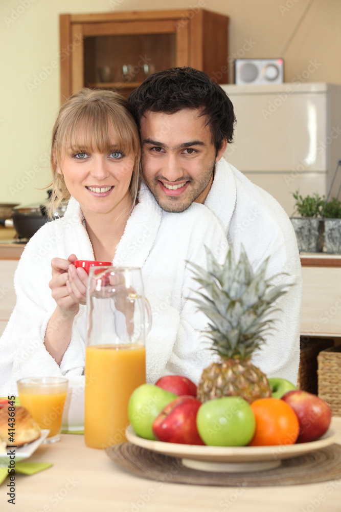 Couple having breakfast in your bathrobe Couple having breakfast in your bathrobe