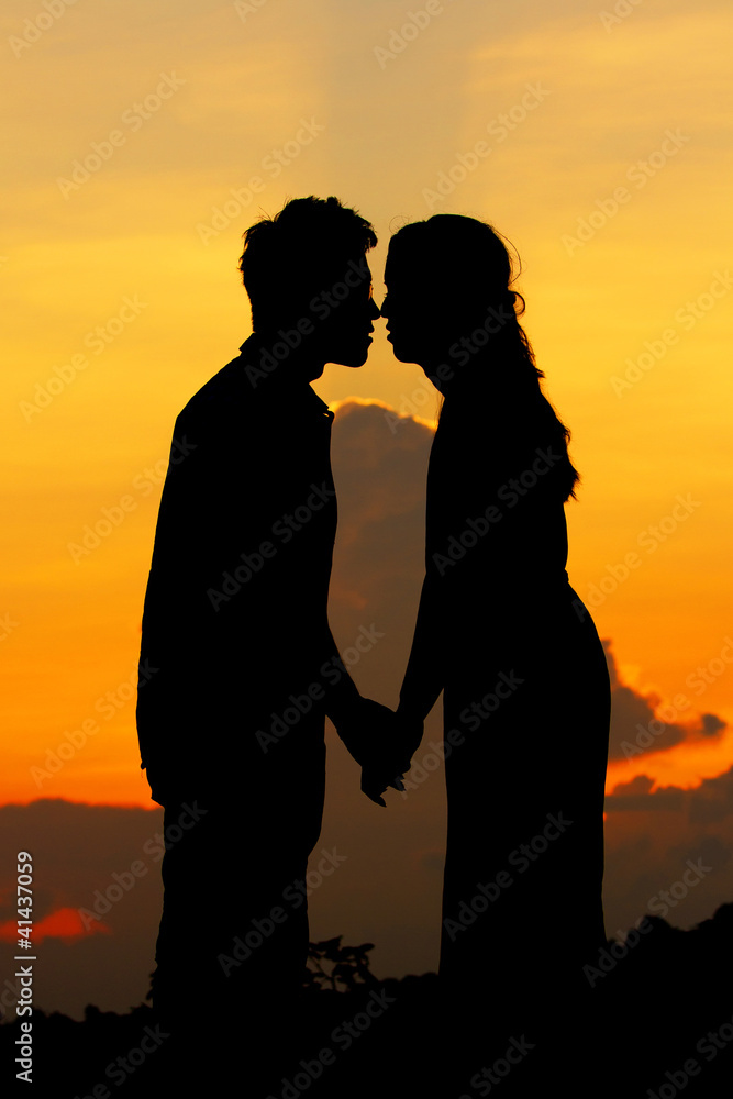 silhouettes of falling in love on sunset