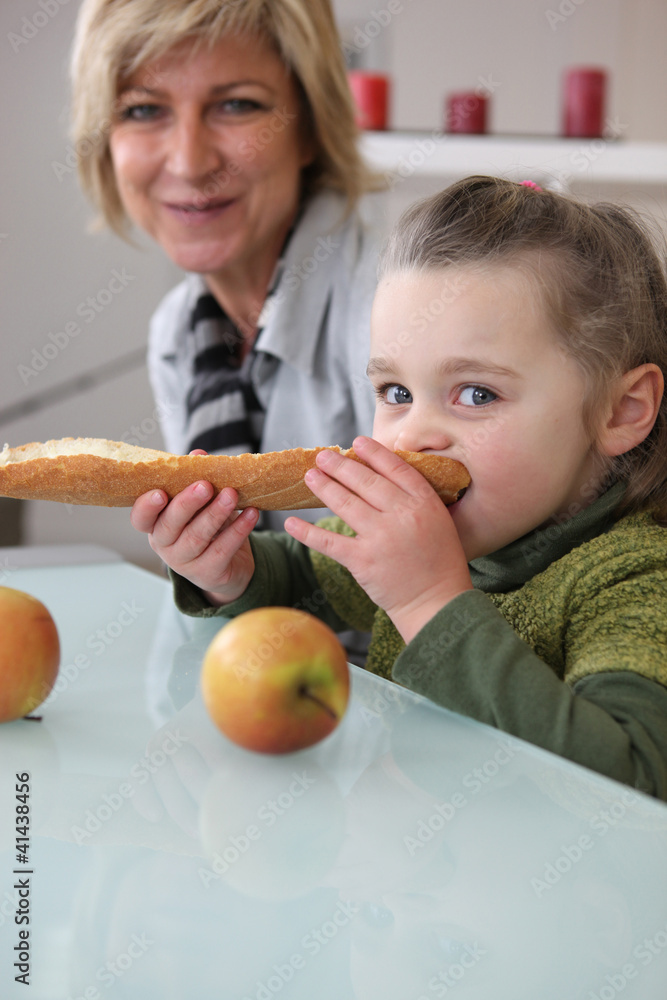 Fototapeta premium Little girl eating bread