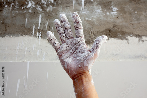 Astist plastering man hand with cracked plaster photo