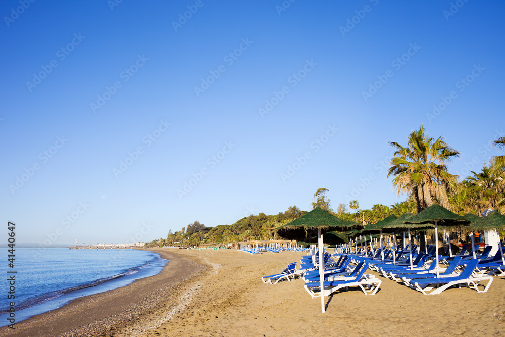 Obraz premium Sun Loungers on a Sandy Beach in Marbella
