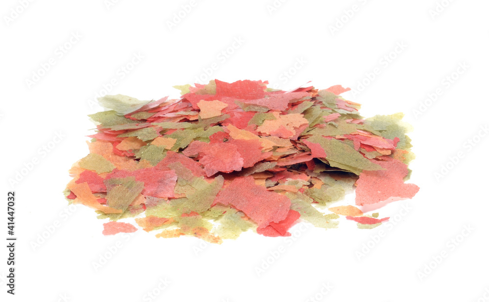 Dried goldfish food flakes on a white background