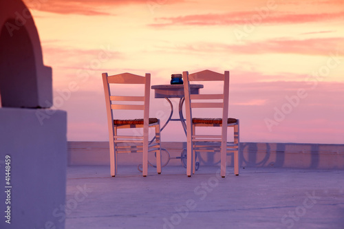 Santorini restaurant with chairs against sunset  Greece