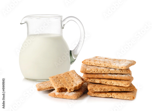 Glass jug with milk and cracker
