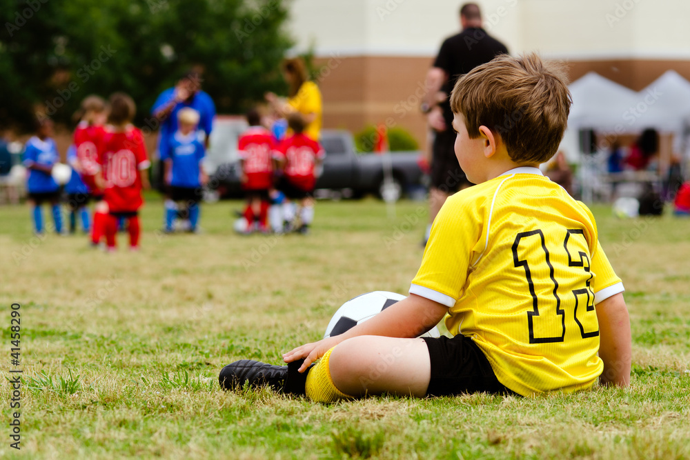 Obraz premium Boy watching organized youth soccer game