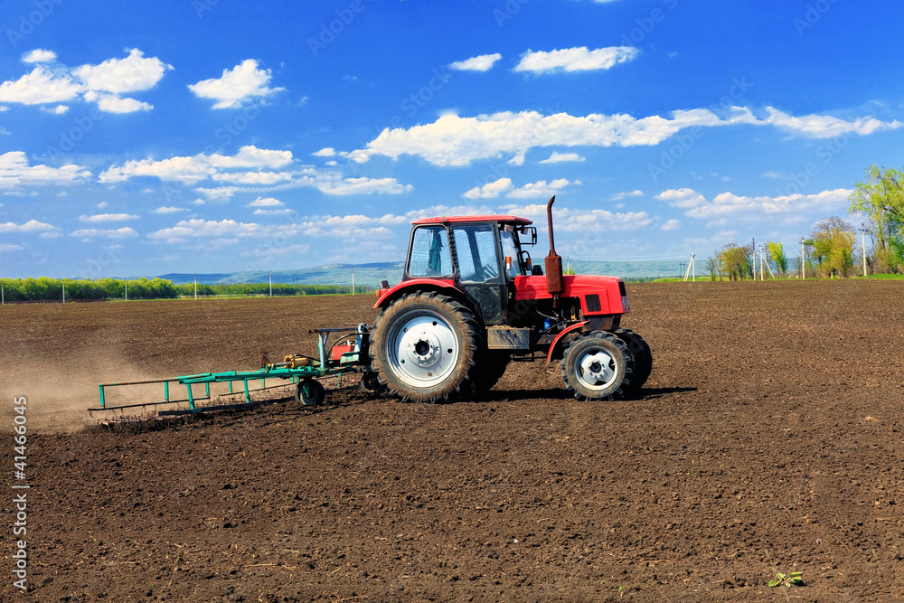 Tractor plowing the fields in early spring. Tractor plowing the fields in early spring.