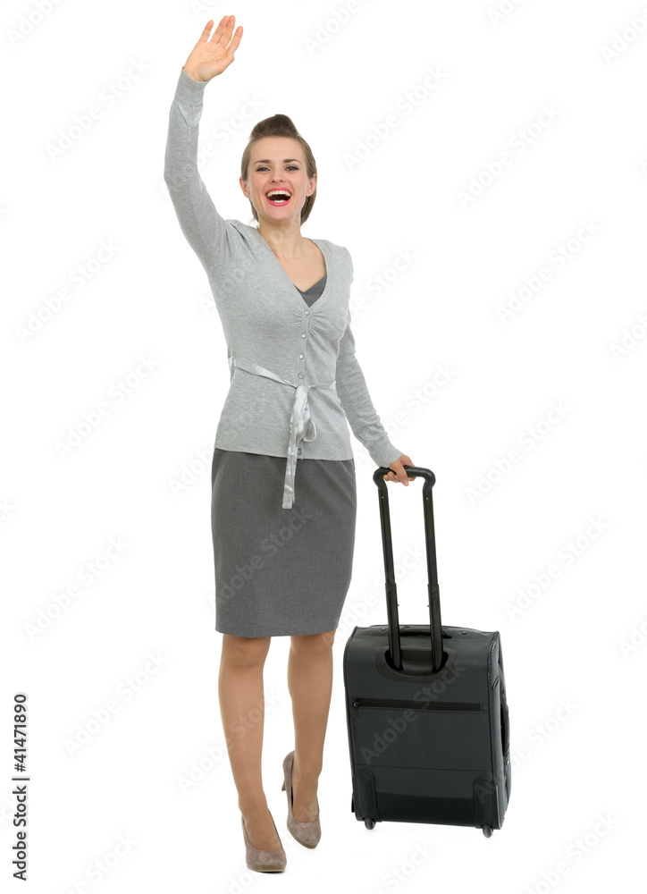 Excited traveling woman with suitcase waving hand Excited traveling woman with suitcase waving hand