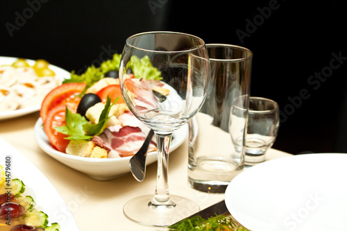 Glasses and plates on table in restaurant - food background