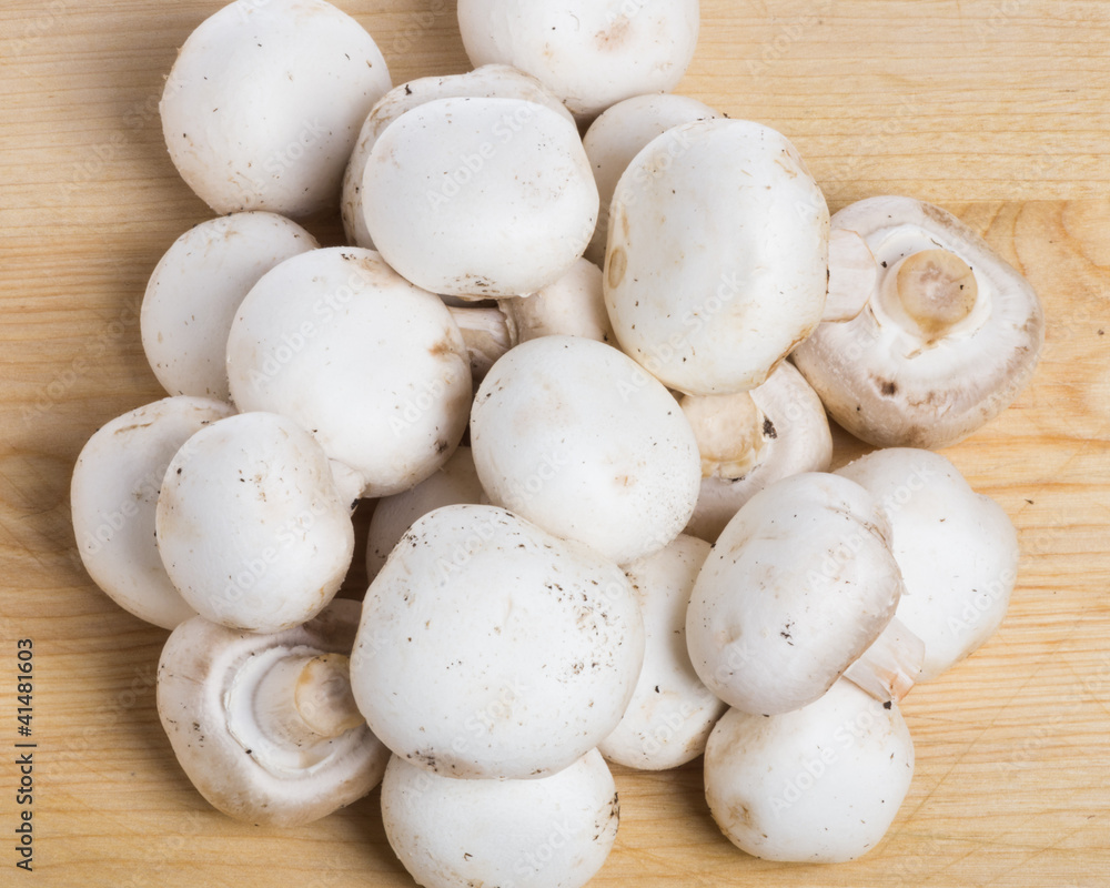 Group of button mushrooms on cutting board Group of button mushrooms on cutting board
