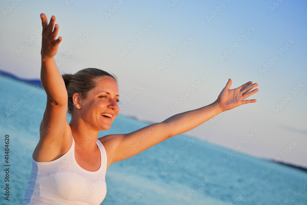 Young woman with hands up expressing joy on the beach Young woman with hands up expressing joy on the beach