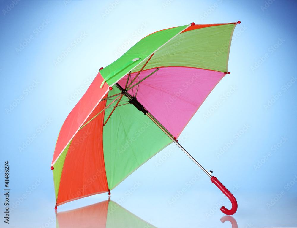 Multi-colored umbrella on blue background