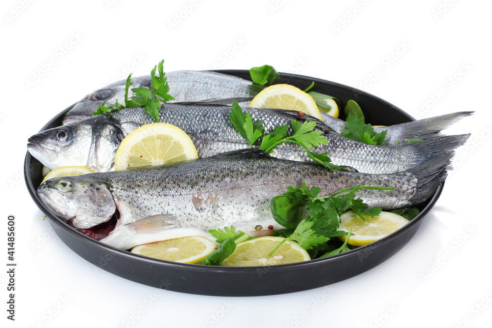 Fresh fishes with lemon and parsley on plate isolated on white Fresh fishes with lemon and parsley on plate isolated on white
