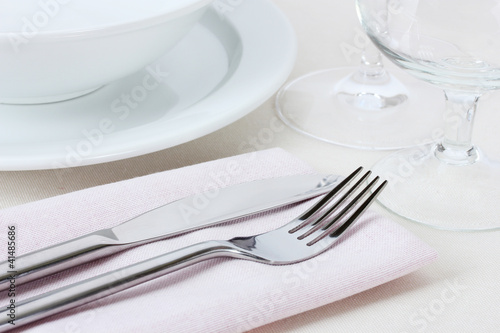 Table setting with fork, knife, plates and napkin