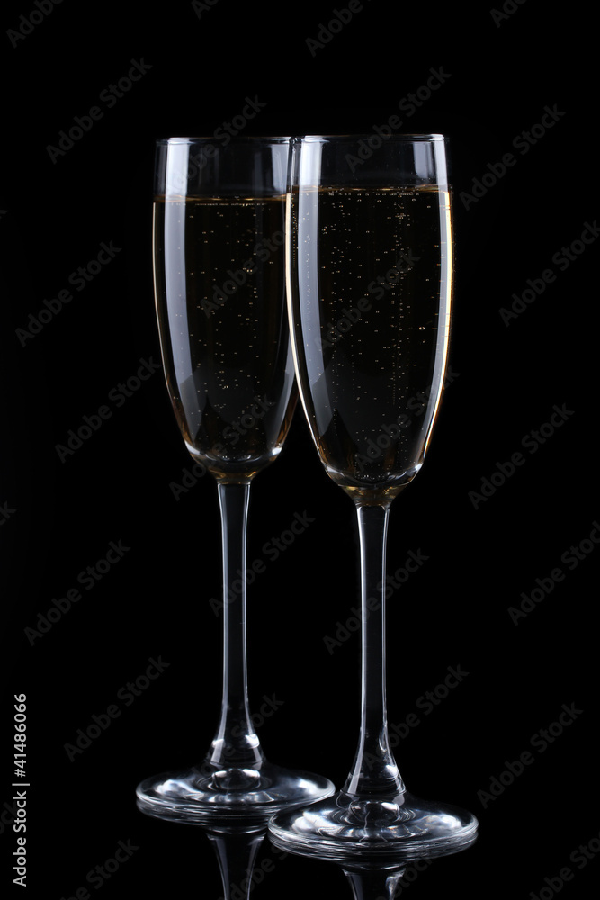 two glasses of champagne on black background