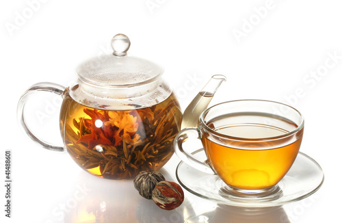 exotic green tea with flowers in glass teapot and cup isolated