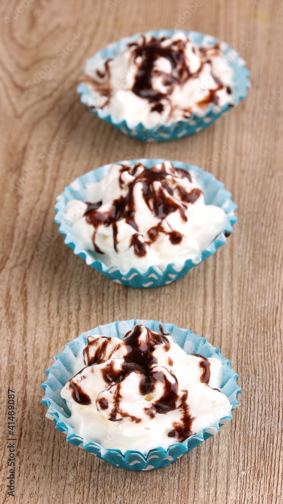 Creamy cupcakes on wooden background
